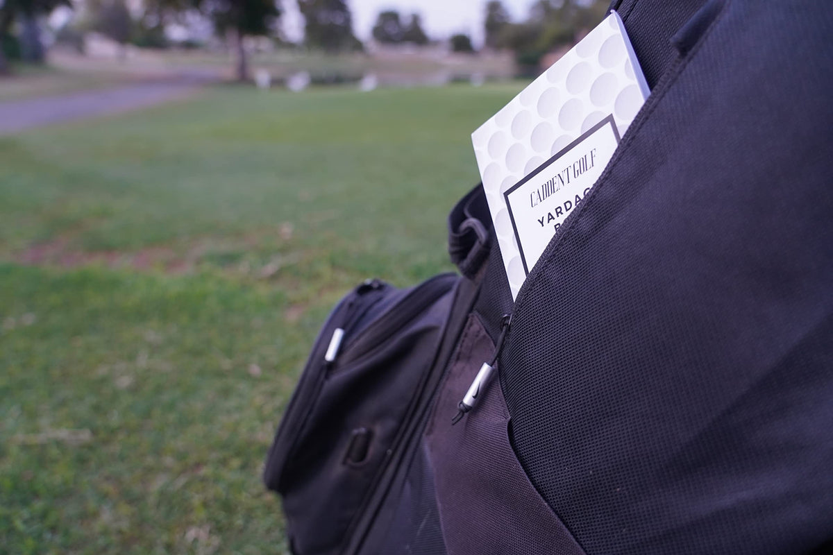 CADDENT GOLF yardage book pocket-size in hand for scale.