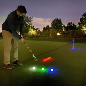 GoSports night golf practice scene showing illuminated balls after dark.
