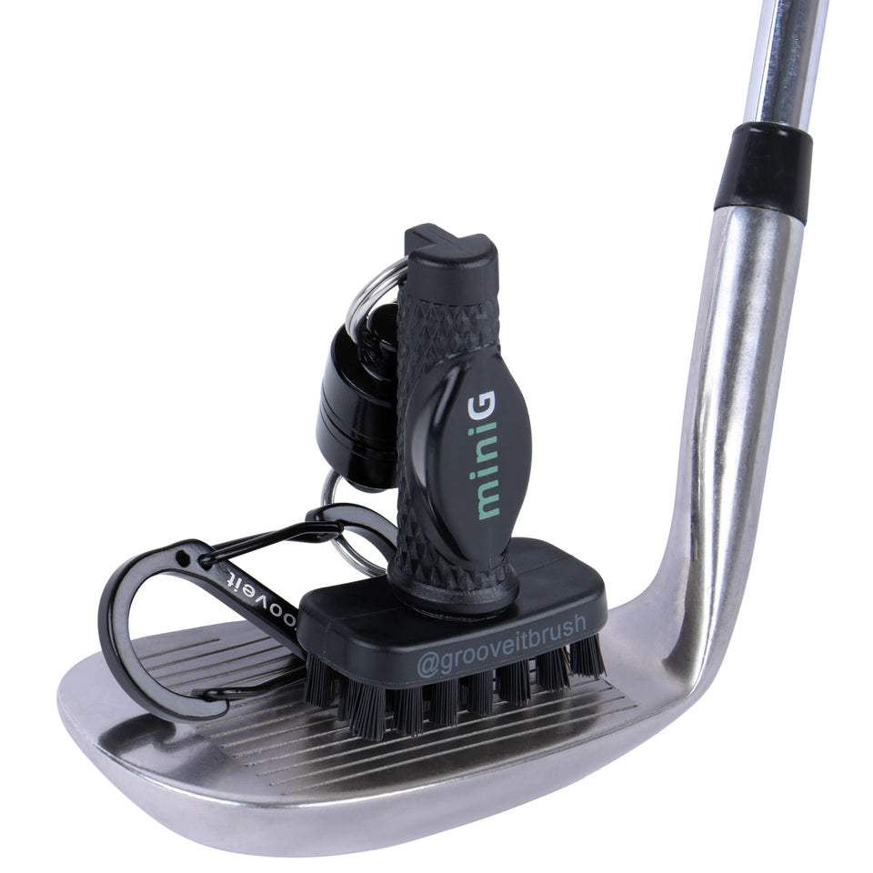 GrooveIt MiniG brush with magnet clip on golf bag for quick on-the-go cleaning.