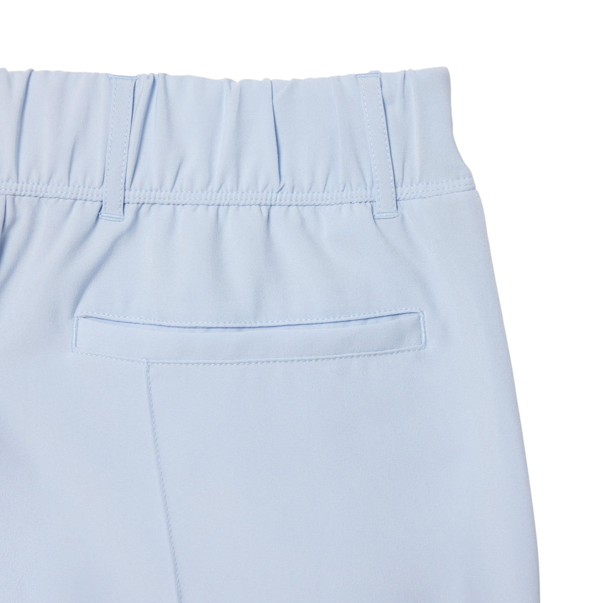 Lacoste Phoenix Blue golf pants on model during swing, sport-ready design.