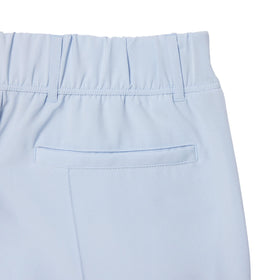 Lacoste Phoenix Blue golf pants on model during swing, sport-ready design.