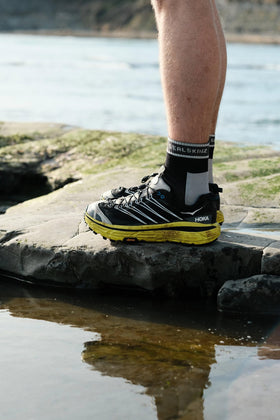SEALSKINZ Holverstone worn on foot showing mid-foot grip during a run