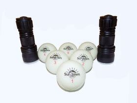 SUNDOWN GOLF glow ball being charged with UV flashlight for bright glow.