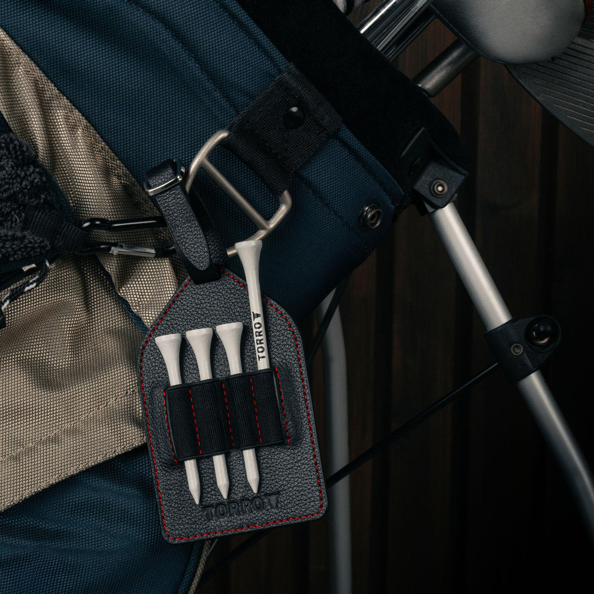 TORRO Tee Holder shown with adjustable strap attached for secure bag mounting.