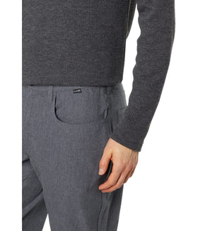 TravisMathew Open to Close pants worn in motion in Heather Dark Grey.