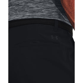 Under Armour men's golf tapered pants in motion on greens showing mobility