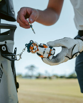 Tee holder clipped onto a bag for fast access during play