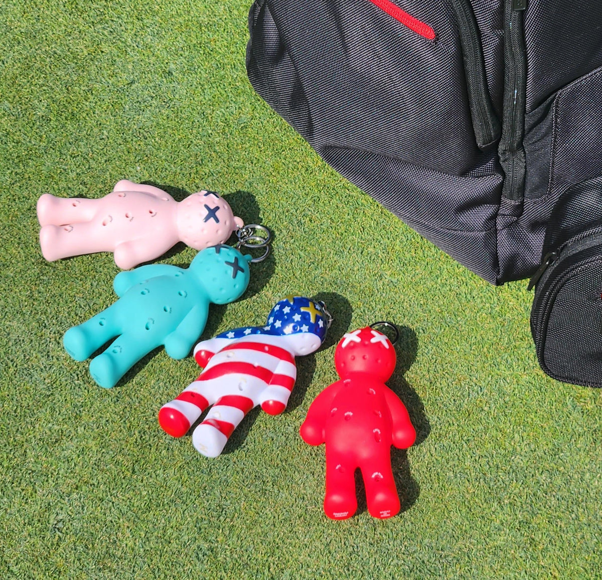 Voodoo Golf Ball Tee Holder attached to a golf bag in pink for easy access.